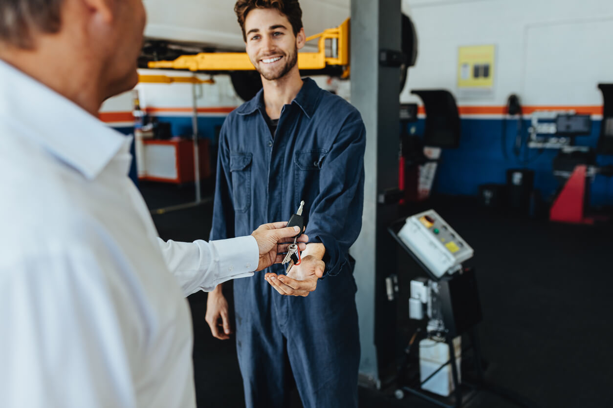 Customer handing car keys to a mechanic.