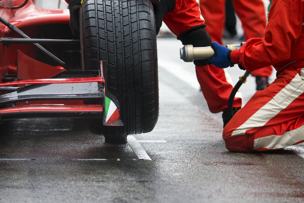 Professional racing team at work during a pitstop of a race car in the pitslane during a car race