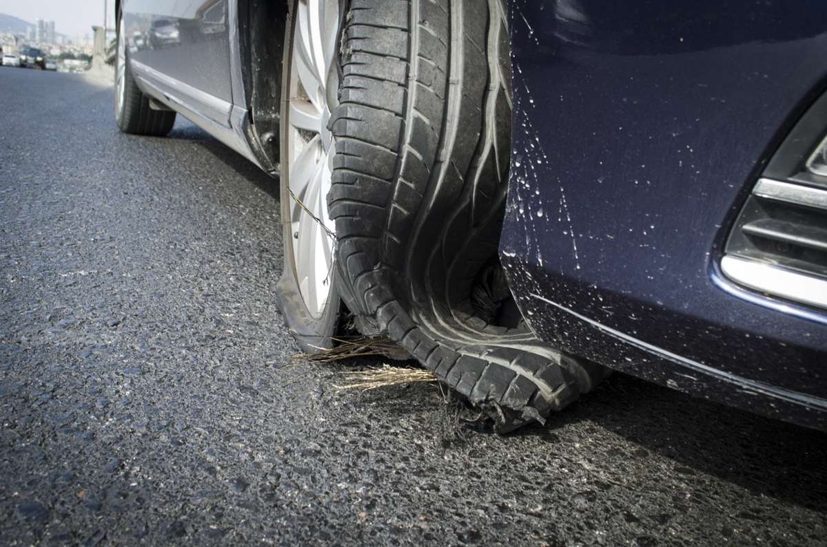 A close-up of a flat car tyre still mounted on the vehicle