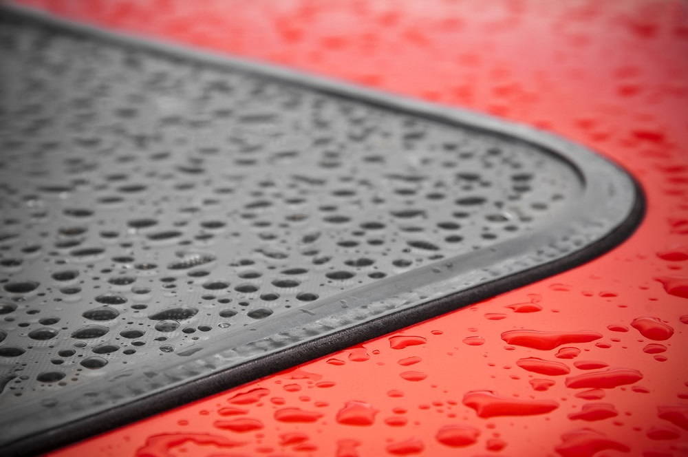 Close up of window rubber seal on red car.