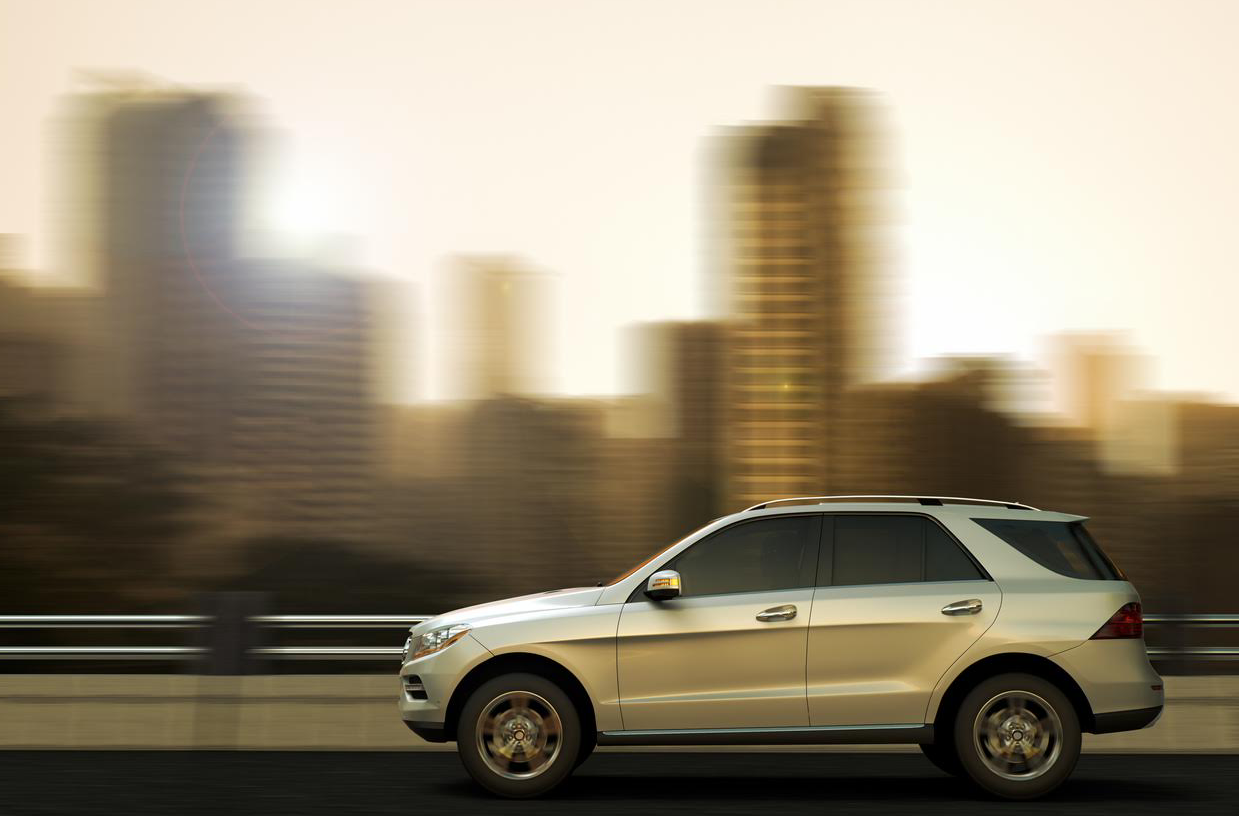 Luxury SUV driving through cityscape.