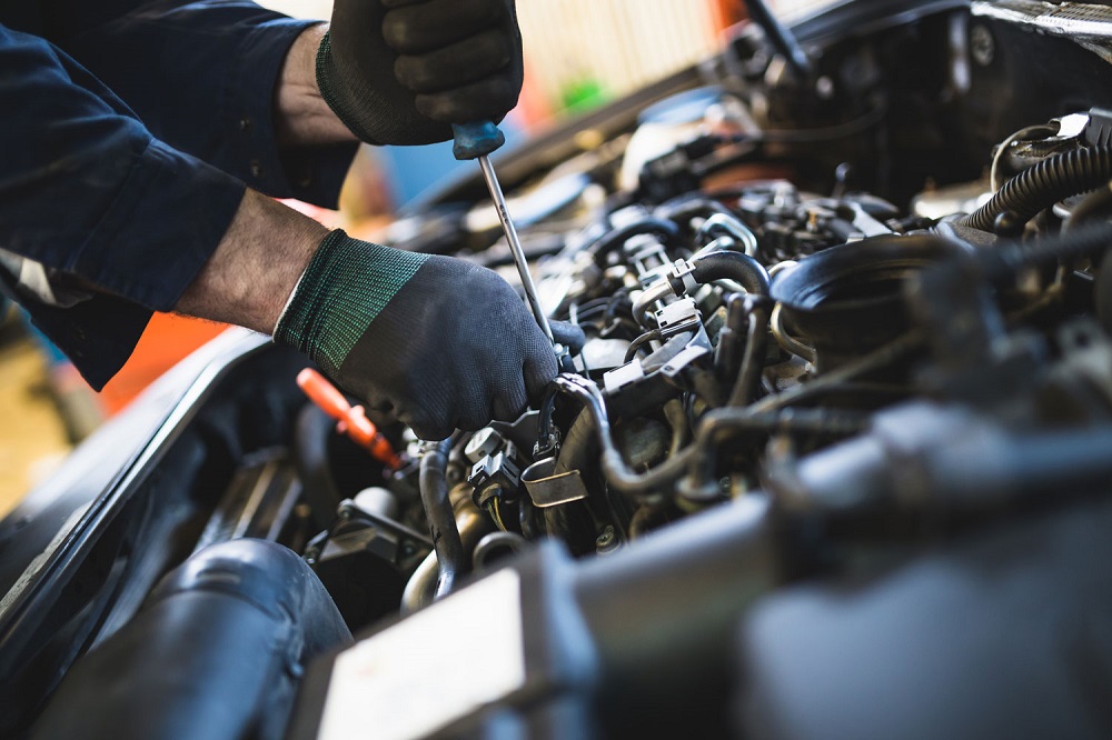 Owner checking over engine of car