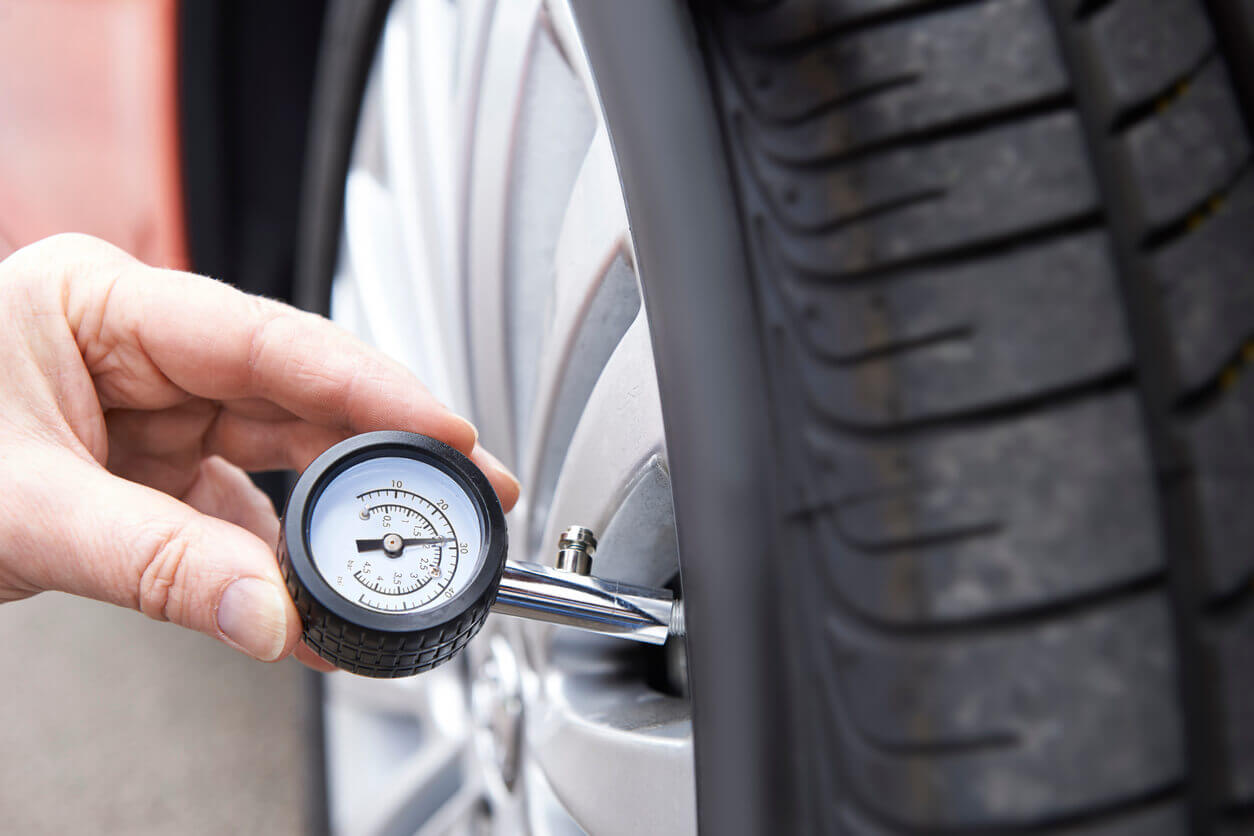 Checking tyre pressure with gauge