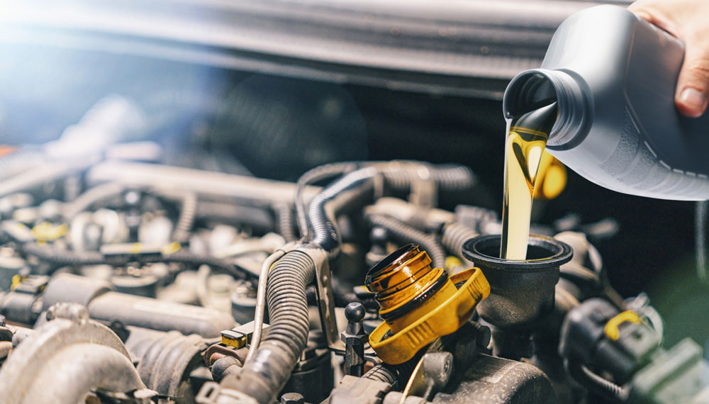 Close up view of oil being poured into the vehicle engine.