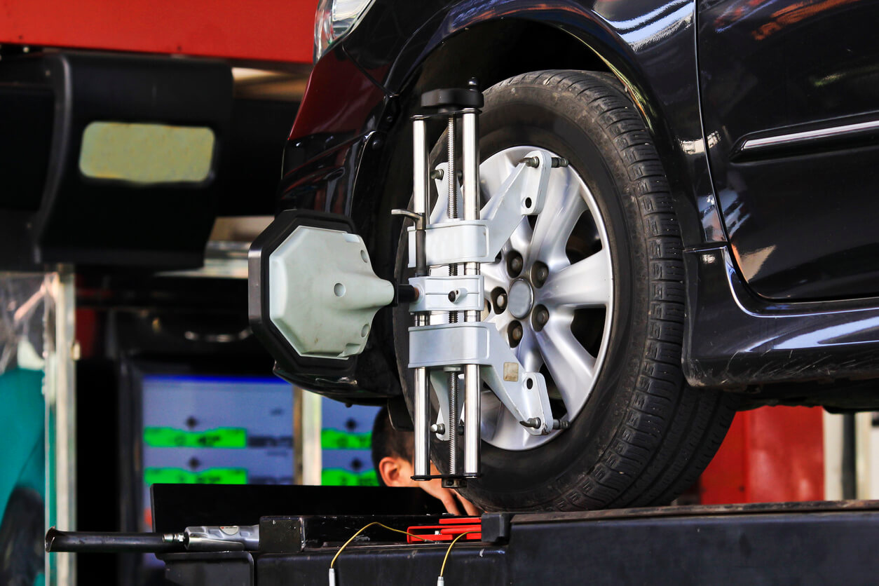 Car wheel fixed with computerized wheel alignment machine clamp.