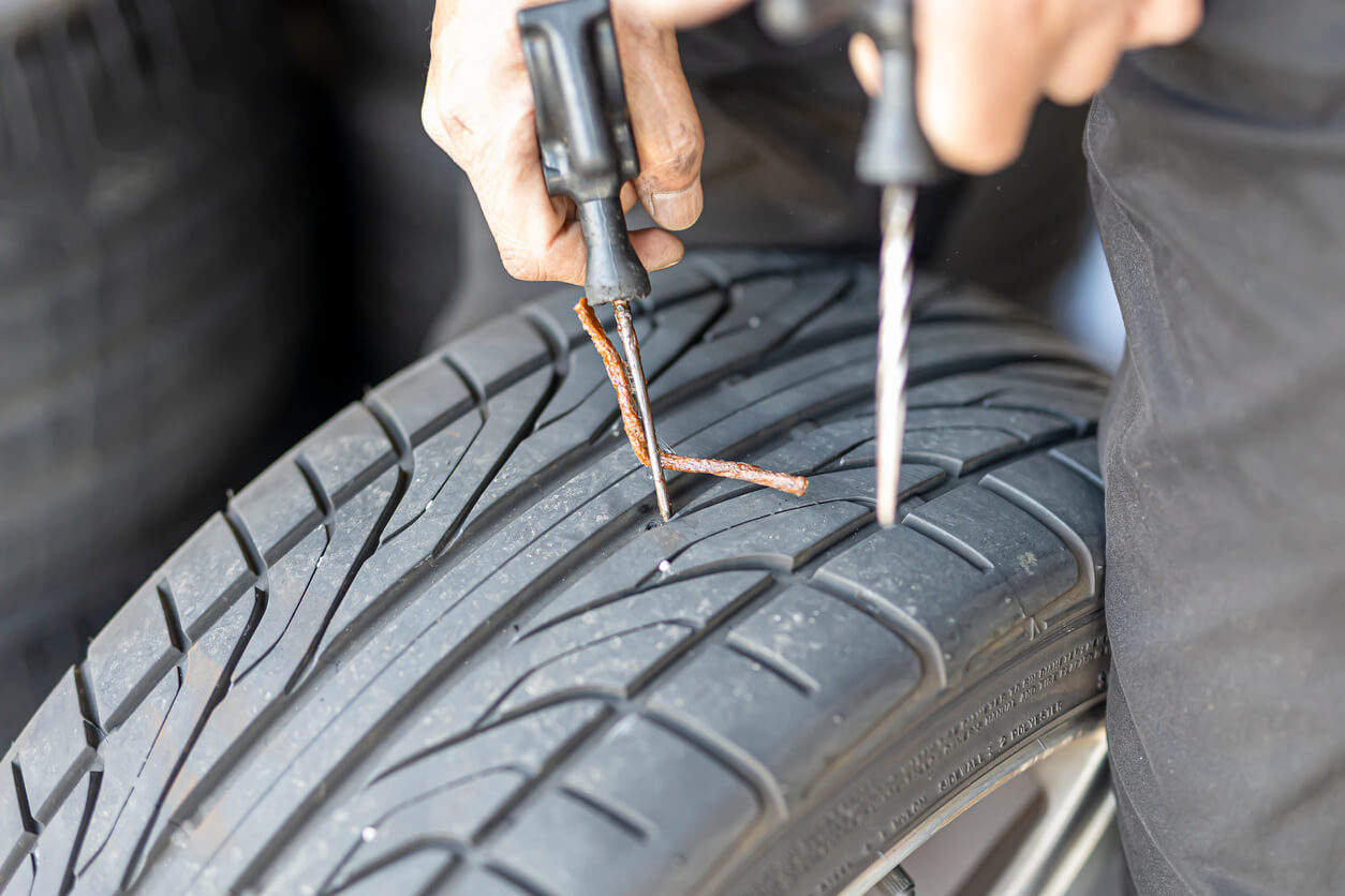 Repairing a tyre puncture with rubber rope kit.